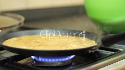 Preparation of pancakes on frying pan.