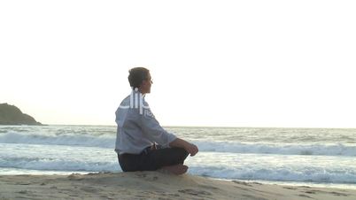 Geschäftsmann meditiert am Strand