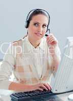 Pensive businesswoman working at a computer with headset on