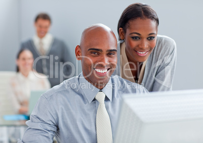 Portrait of two ethnic colleagues working at a computer
