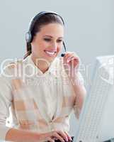 Smiling businesswoman working at a computer with headset on