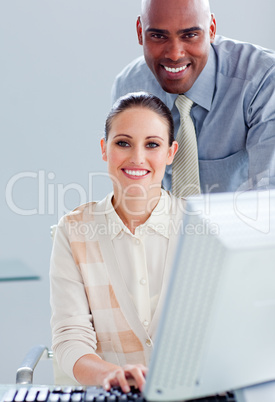 Smiling businesswoman and her manager working at a computer