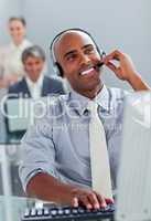 Cheerful businessman working at a computer with headset on