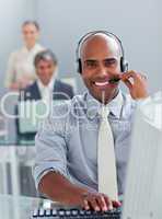 Ethnic businessman working at a computer with headset on