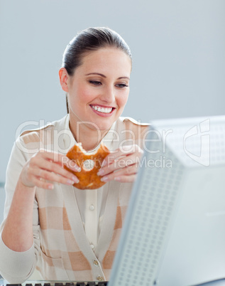 Portrait of a caucasian businesswoman eating donnuts in her offi