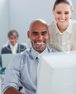 Two positive business colleagues working at a computer