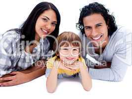 Cheerful parents with their son lying on the floor