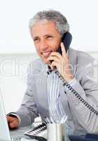 Positive mature businessman talking on phone