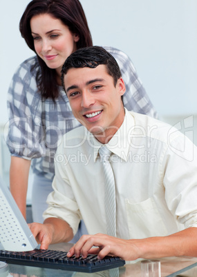 Smiling colleagues working together at a computer