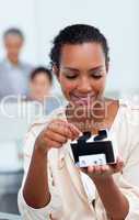 Smiling businesswoman consulting a business card holder