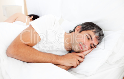 Upset man lying in his bed