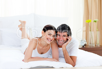 Romantic couple embracing lying on their bed