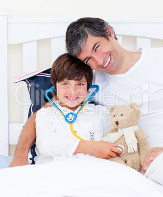 Attentive father and his sick son playing with a stethoscope