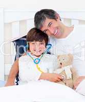 Attentive father and his sick son playing with a stethoscope