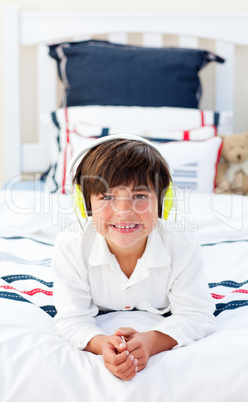 Smiling little boy listening music with headphones on