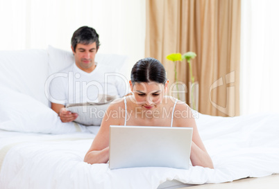 Caucasian couple relaxing on their bed