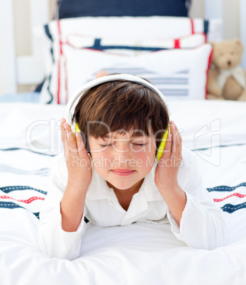 Adorable little boy listening music with headphones on