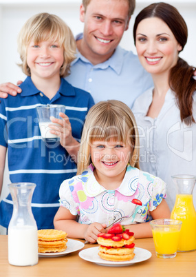 Joyful family eating breakfast in the kitchen