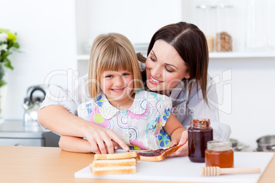 Smiling little girl and her mother preparing toasts