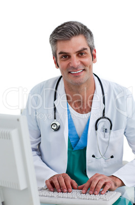 Mature male doctor working at a computer