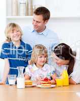 Jolly family eating breakfast in the kitchen