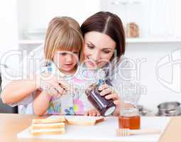 Adorable little girl and her mother preparing toasts