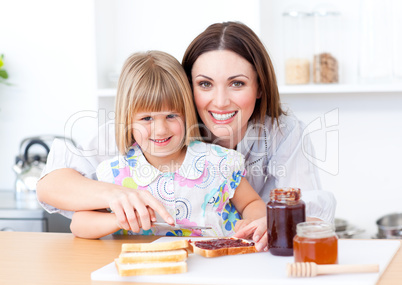 Blond little girl and her mother preparing toasts