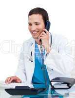 Young male doctor on phone working at a computer