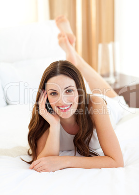 Charming woman on phone lying on bed