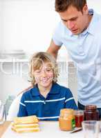 Blond little boy and his father preparing breakfast