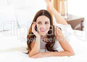 Pretty woman on phone lying on bed