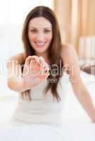 Attractive woman taking a pill sitting on bed
