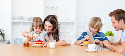 Happy family eating breakfast in the kitchen