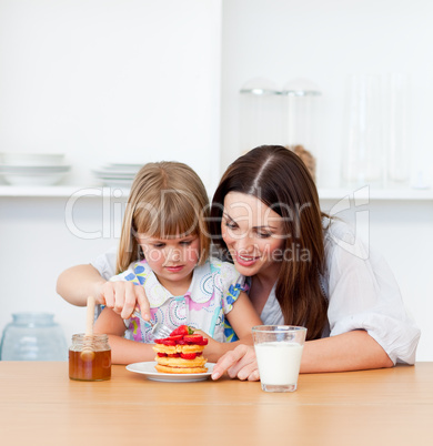 Loving little girl and her mother having breakfast