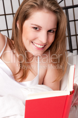 Frau mit Buch im Bett