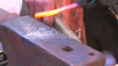 HD Glowing iron ready for blacksmith with hammer, closeup