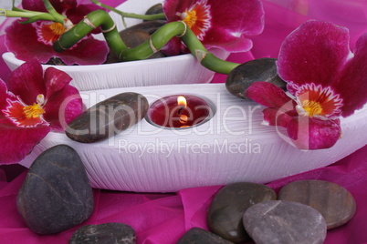 Orchideenblüten mit Teelicht und Bambus