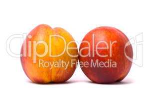 Two juicy nectarines on a white background