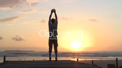 Mann macht Yogaübungen am Meer