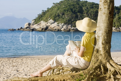 Frau liest Buch am Strand