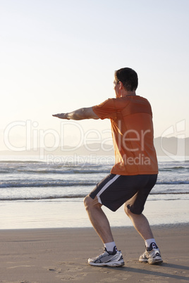 Jogger macht Kniebeugen am Strand