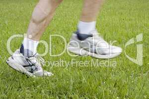 Beine eines Läufer im Gras
