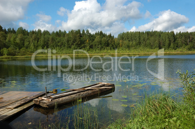 Old wooden boat near the lake bank