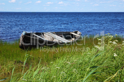 Old wooden boat on the lake bank