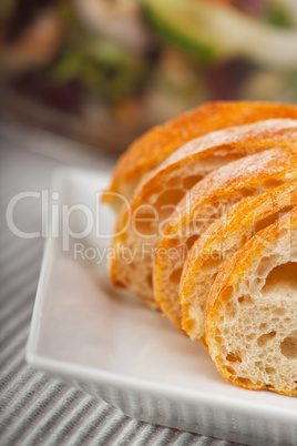 Nahaufnahme von Baguettescheiben mit einem Salat als Hintergrund