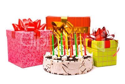 Pie with twelve candles and gifts in boxes on a white background