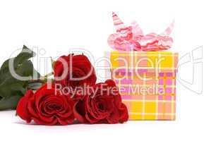 Red roses and gift box on a studio white background.