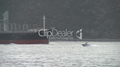 speedboat passes logging ship