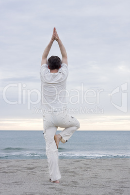 Mann macht Yoga am Strand