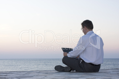 Geschäftsmann mit Laptop am Meer